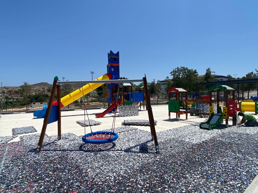Parque infantil con columpios y suelo de seguridad